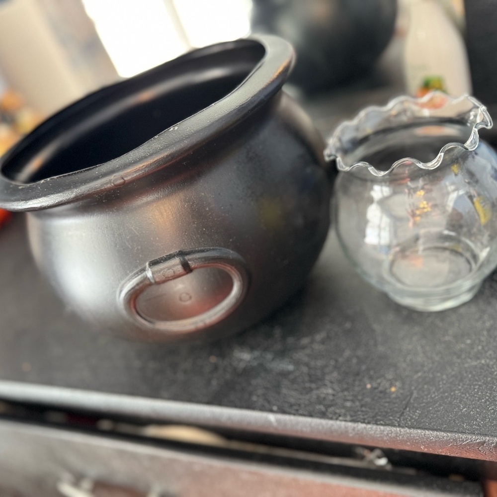 Set of 2 bowls, one black deep plastic one glass round with accented edges.